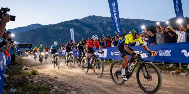Thrilling moment from the 2026 MTB World Championships showcasing athletes racing in rugged terrain, highlighting news ciclismo excitement